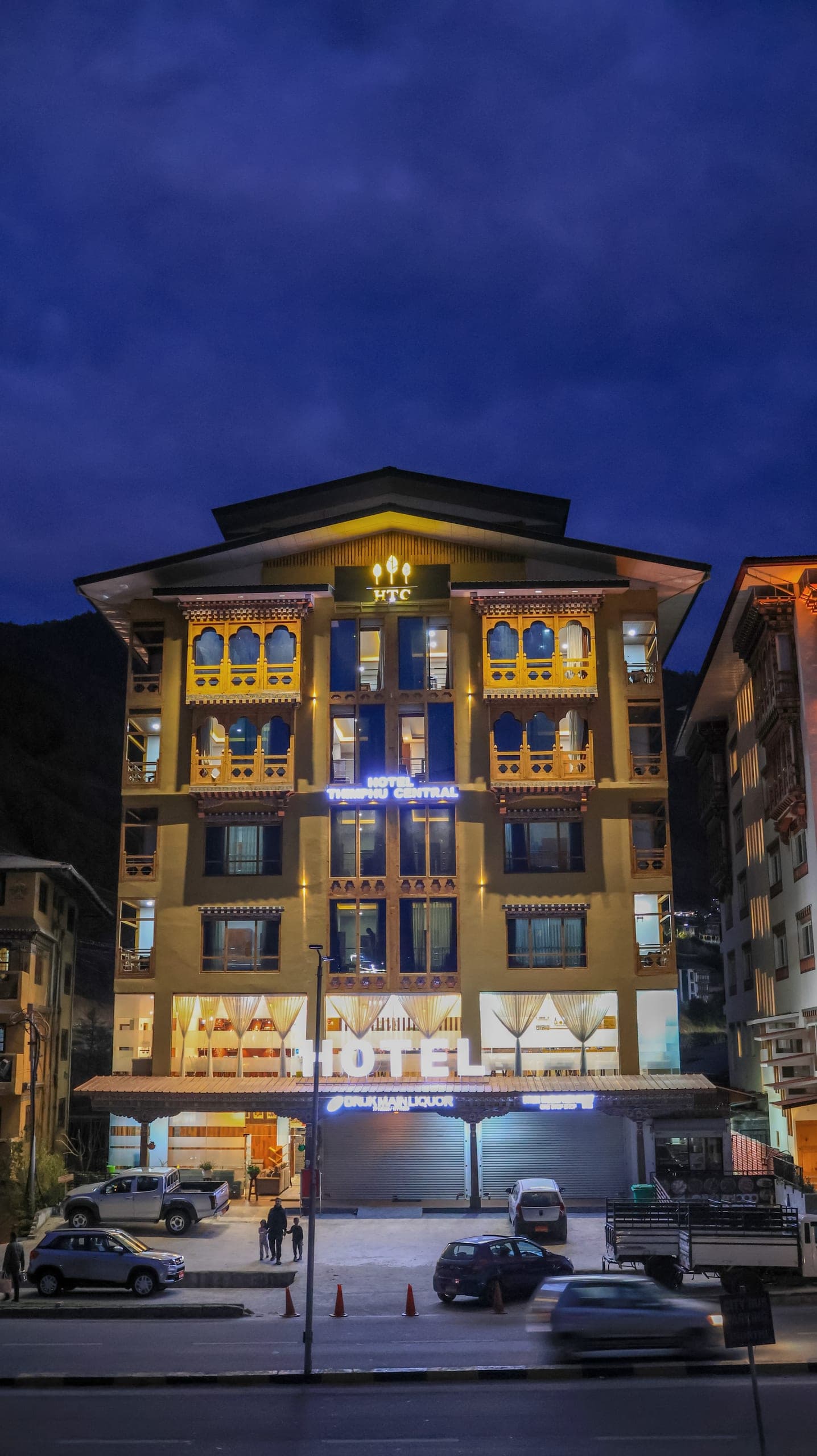 Hotel Thimphu Central's Bhutanese-style building lit up at dusk