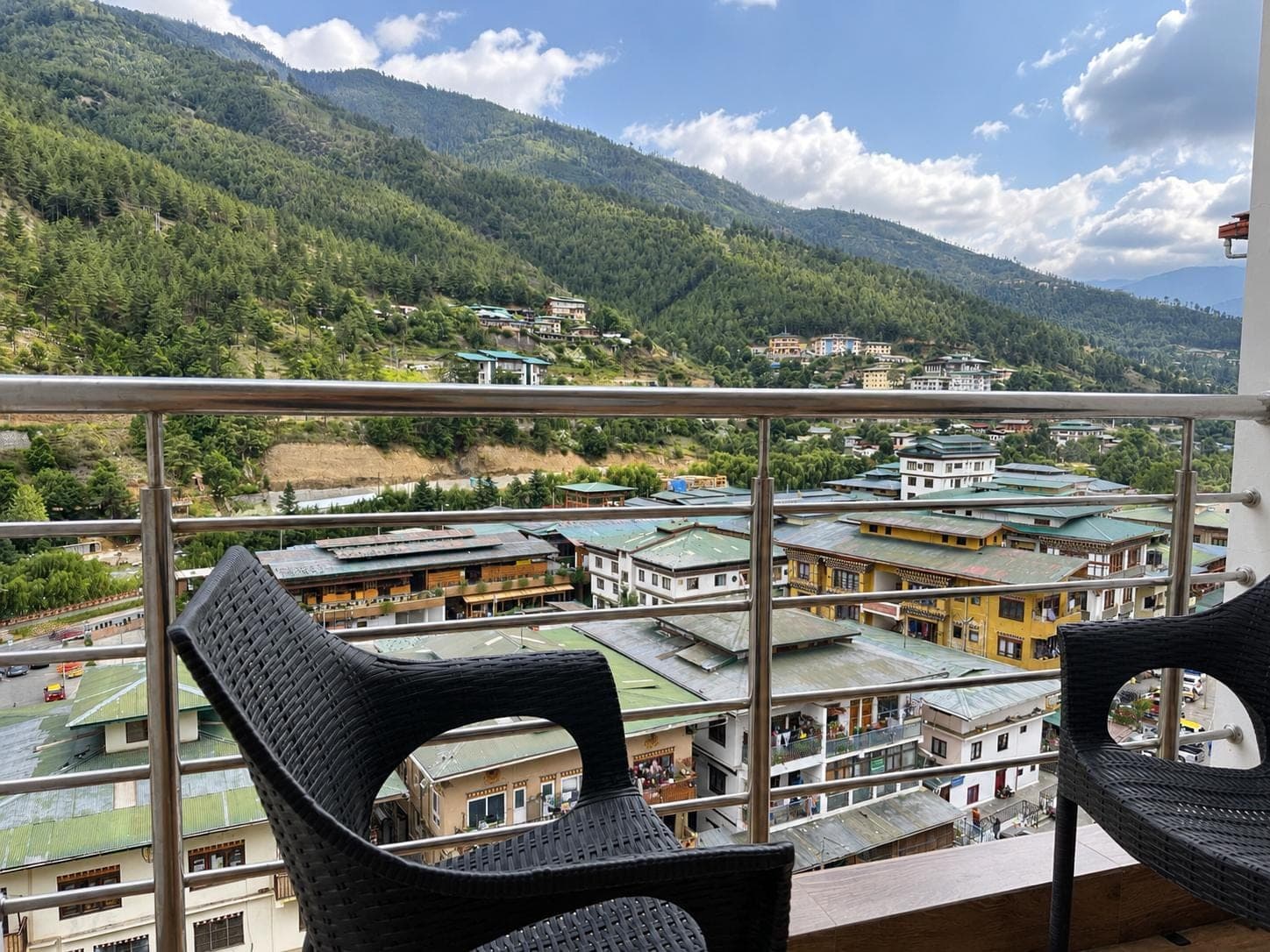 Balcony chairs overlooking the town and mountains under a blue sky